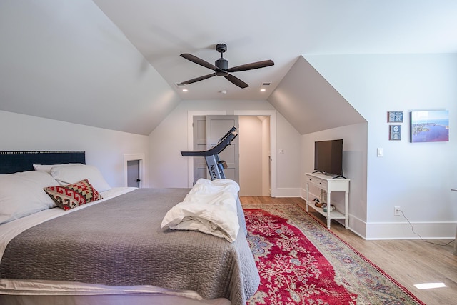 bedroom with vaulted ceiling, wood finished floors, baseboards, and ceiling fan