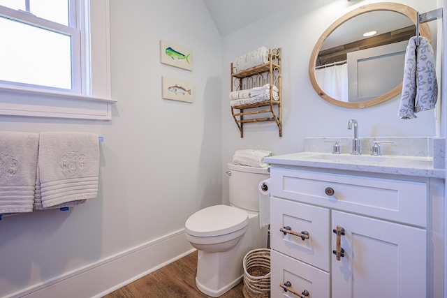 bathroom featuring baseboards, toilet, lofted ceiling, wood finished floors, and vanity