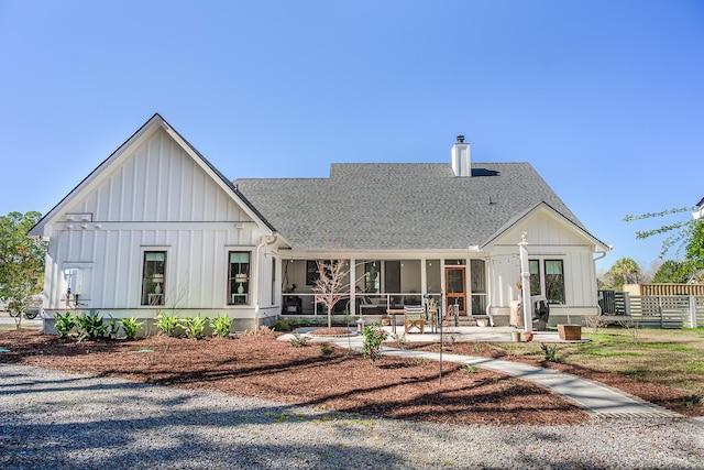 view of front of property with a patio, board and batten siding, and roof with shingles