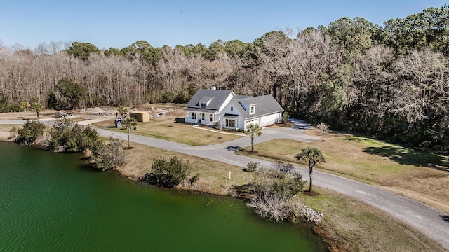 birds eye view of property with a water view and a wooded view