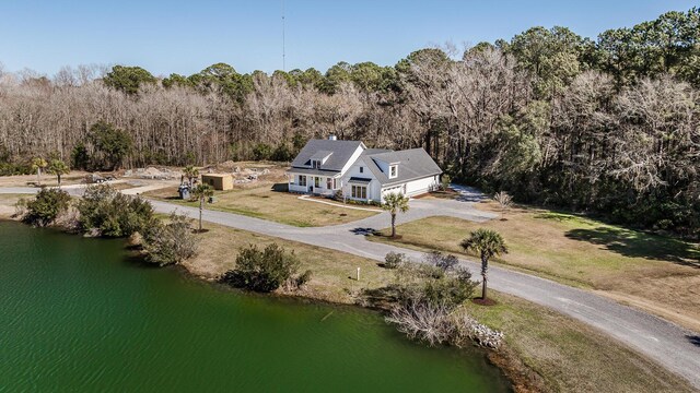 birds eye view of property with a water view and a view of trees