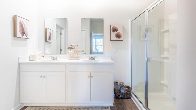 bathroom with wood-type flooring, a shower with door, and vanity