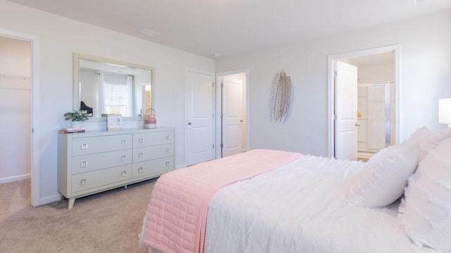 carpeted bedroom with a closet, connected bathroom, and a walk in closet