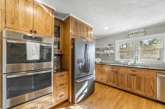 kitchen with light hardwood / wood-style floors, sink, stainless steel appliances, and ornamental molding