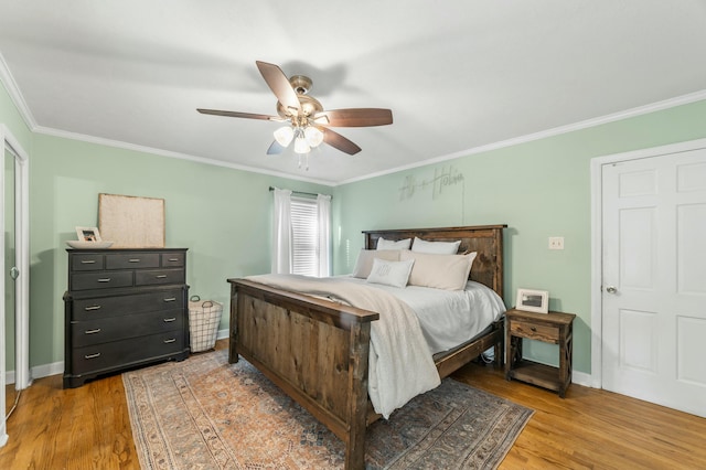 bedroom featuring ceiling fan, crown molding, and light hardwood / wood-style flooring