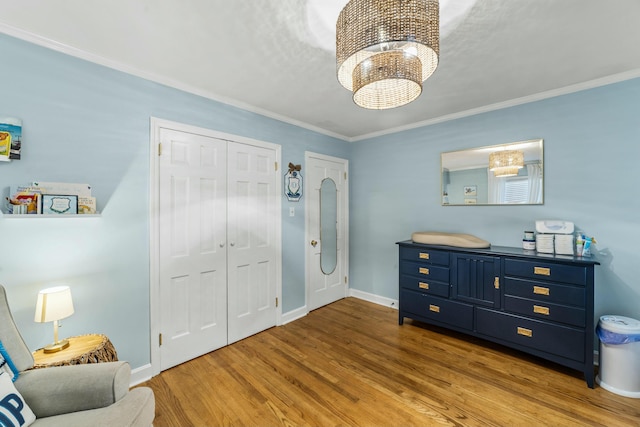 foyer entrance with hardwood / wood-style flooring, ornamental molding, and a notable chandelier