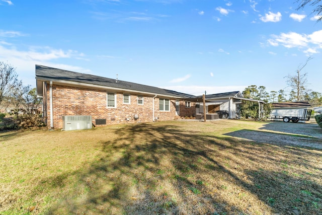 back of house with a yard and central AC unit