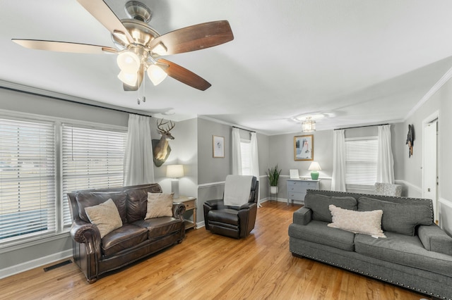 living room with crown molding, light hardwood / wood-style flooring, and ceiling fan