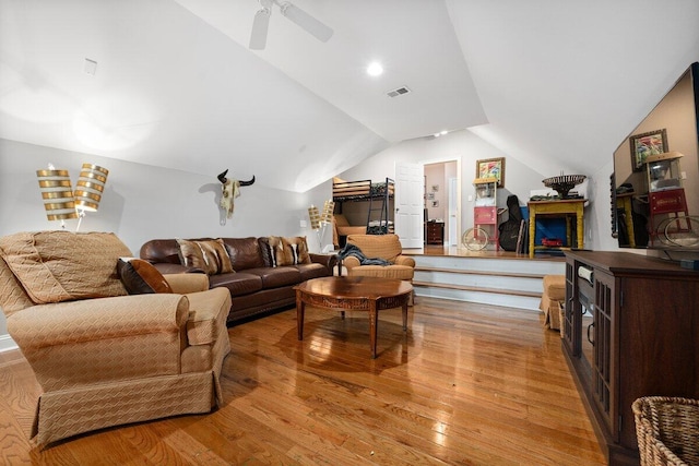 living room featuring ceiling fan, vaulted ceiling, and light wood-type flooring