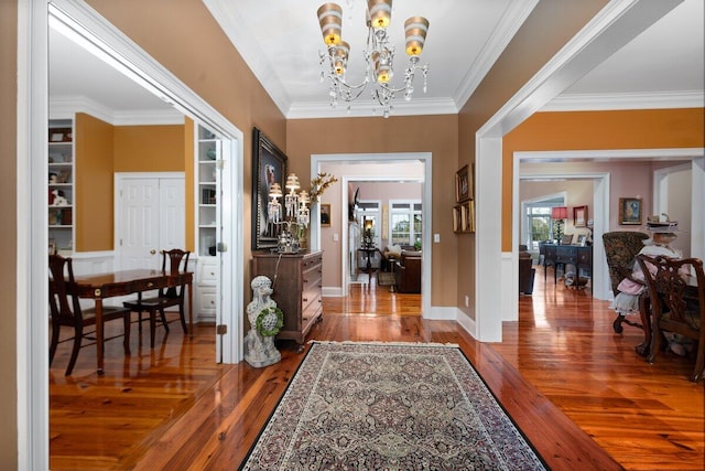 foyer with crown molding, a notable chandelier, and dark hardwood / wood-style floors