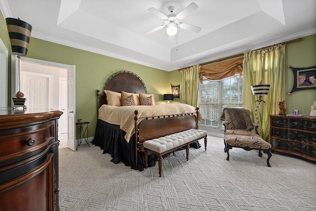 carpeted bedroom featuring ceiling fan, a raised ceiling, and ornamental molding