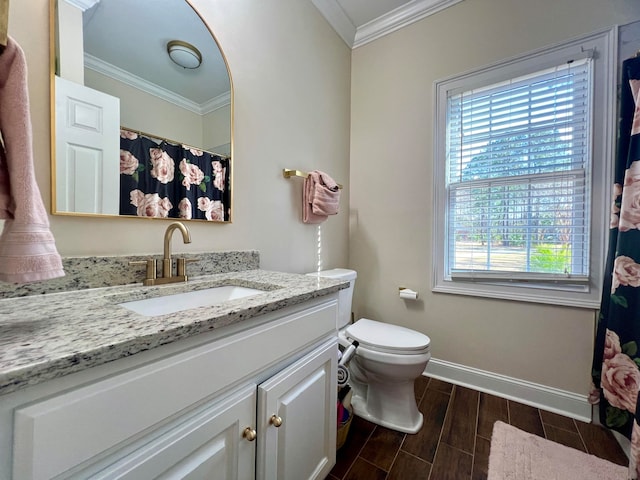 bathroom with plenty of natural light, large vanity, toilet, and crown molding