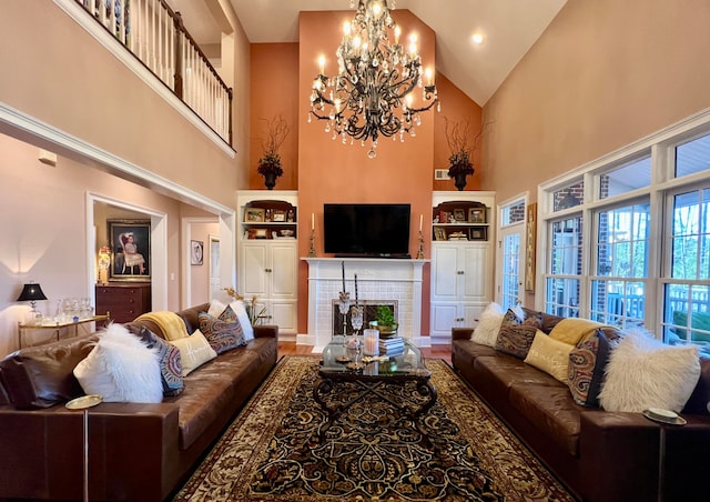 living room with a fireplace, high vaulted ceiling, and a chandelier