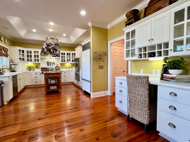 kitchen featuring dark hardwood / wood-style floors, a tray ceiling, and white cabinets