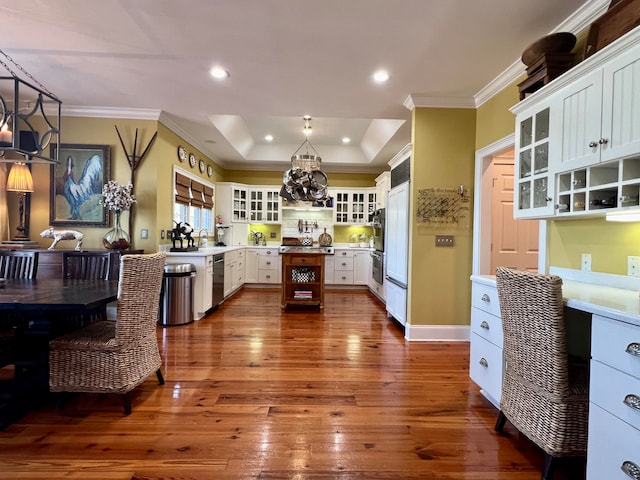 kitchen featuring a center island, dark hardwood / wood-style floors, a tray ceiling, and pendant lighting