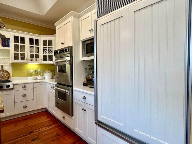 kitchen with dark hardwood / wood-style flooring, white cabinetry, and stainless steel appliances