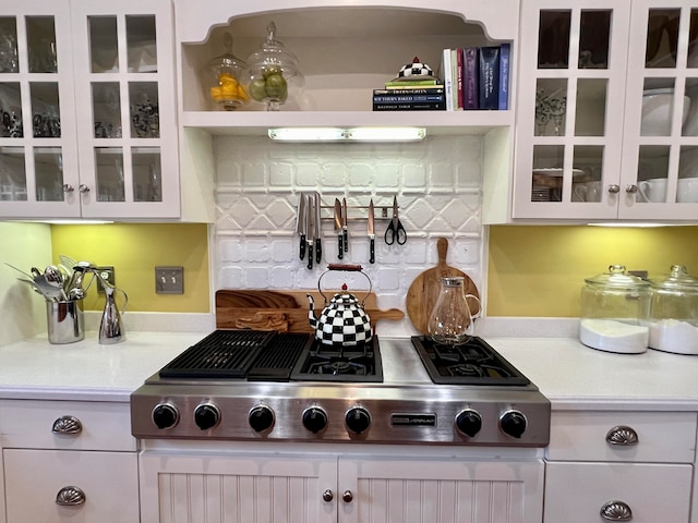 kitchen featuring white cabinets, stainless steel gas stovetop, and tasteful backsplash