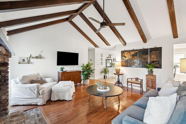 living room with beamed ceiling, high vaulted ceiling, a ceiling fan, and wood finished floors