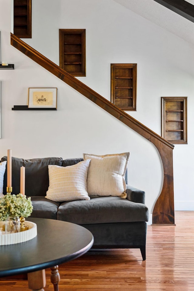 living area featuring wood finished floors, stairs, and vaulted ceiling