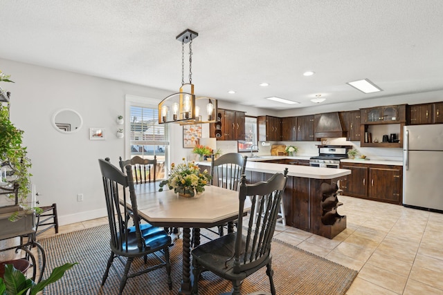 dining space featuring a wealth of natural light, light tile patterned floors, and a textured ceiling