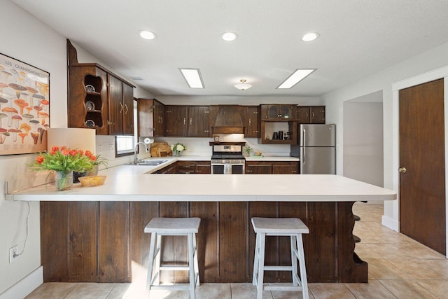 kitchen with a sink, appliances with stainless steel finishes, light countertops, and open shelves