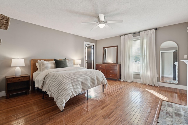 bedroom with baseboards, a textured ceiling, a ceiling fan, and hardwood / wood-style floors