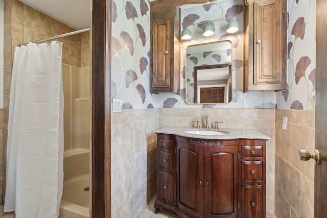 full bath featuring a shower with shower curtain, tile walls, and vanity