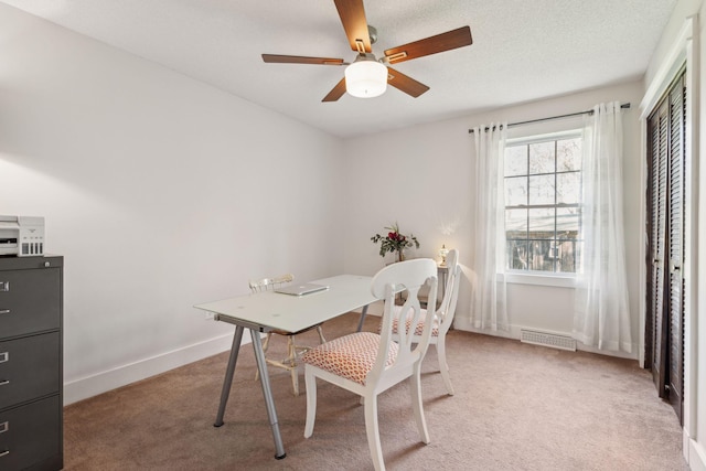 home office featuring ceiling fan, baseboards, visible vents, and light carpet