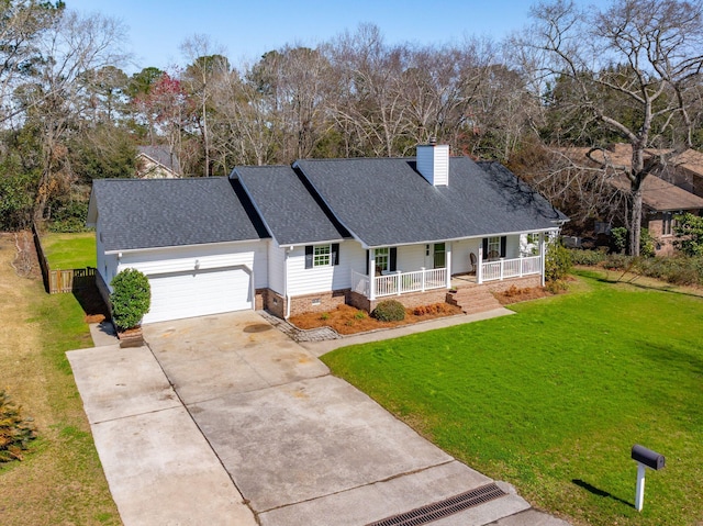 view of front of property with a front lawn, concrete driveway, roof with shingles, covered porch, and a garage