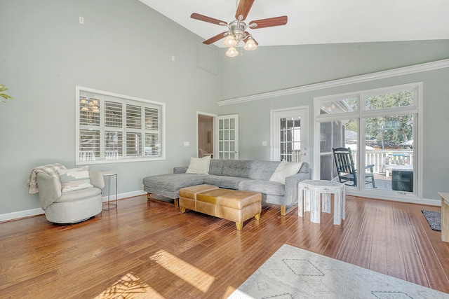 living room featuring high vaulted ceiling, ceiling fan, baseboards, and wood finished floors