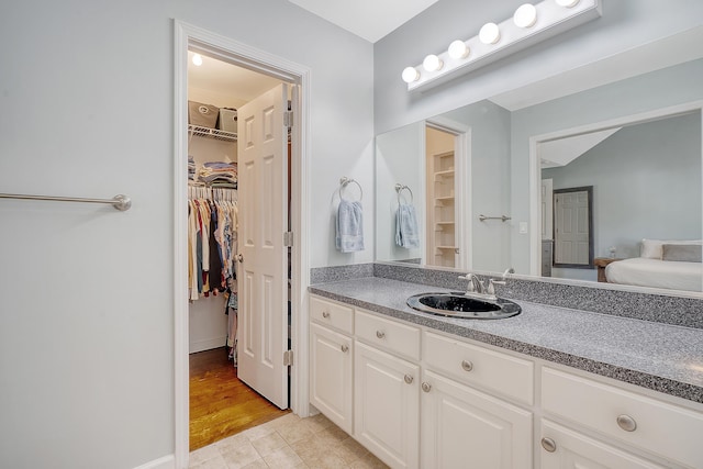 full bathroom with a spacious closet and vanity