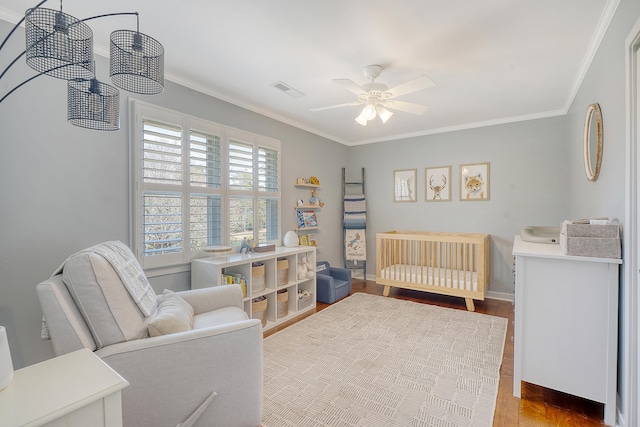 bedroom featuring visible vents, baseboards, ceiling fan, wood finished floors, and crown molding