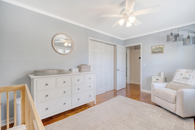 bedroom with visible vents, ornamental molding, a ceiling fan, wood finished floors, and baseboards