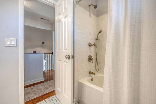 bathroom featuring visible vents and shower / bathtub combination with curtain