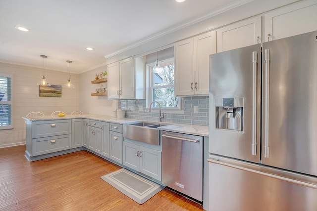 kitchen with open shelves, stainless steel appliances, hanging light fixtures, light stone countertops, and light wood-type flooring