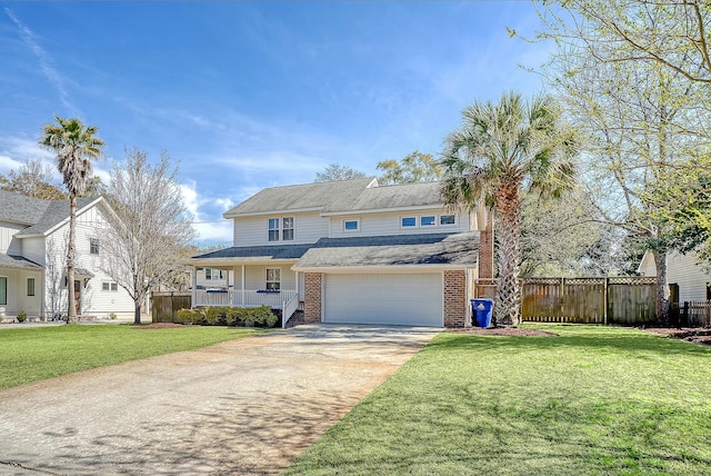 traditional-style home featuring driveway, a front yard, fence, and brick siding