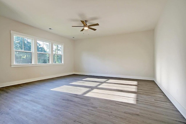 empty room with dark hardwood / wood-style flooring and ceiling fan