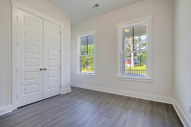 unfurnished bedroom featuring a closet and dark hardwood / wood-style floors