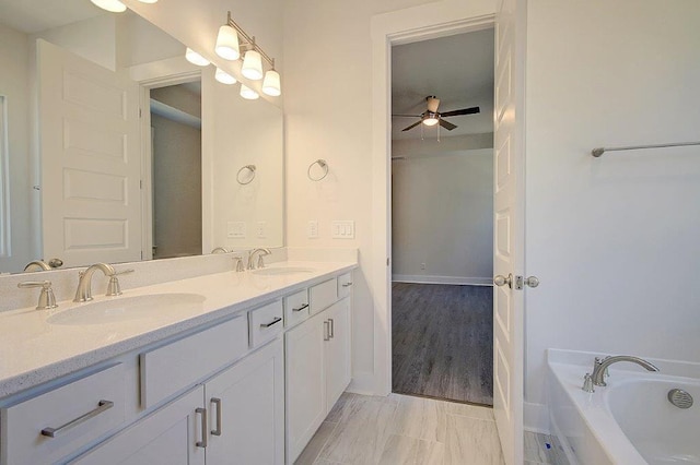 bathroom featuring ceiling fan, a bathtub, and vanity