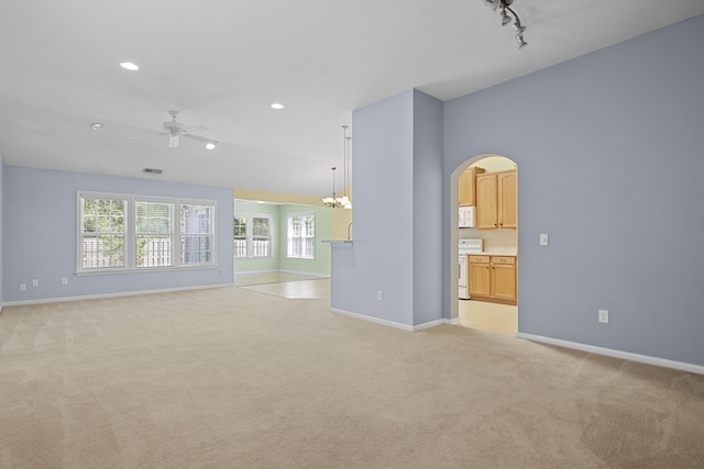 261 Sweet Alyssum Dr, Ladson, SC 29456 - unfurnished living room featuring arched walkways, light carpet, a ceiling fan, baseboards, and plenty of natural light