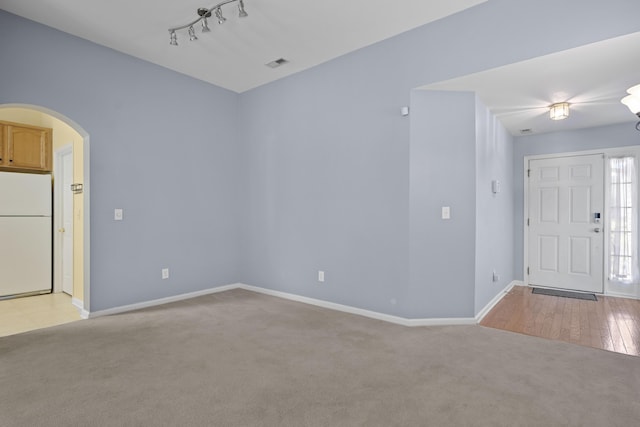 261 Sweet Alyssum Dr, Ladson, SC 29456 - empty room with light carpet, arched walkways, baseboards, and rail lighting