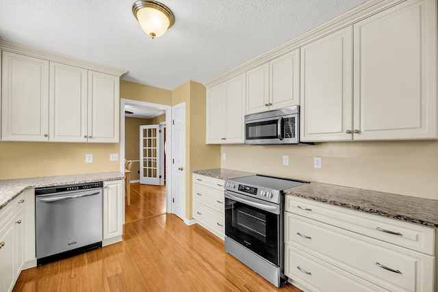 721 Lake Frances Dr, Charleston, SC 29412 - kitchen with appliances with stainless steel finishes, light wood-style floors, a textured ceiling, and stone countertops