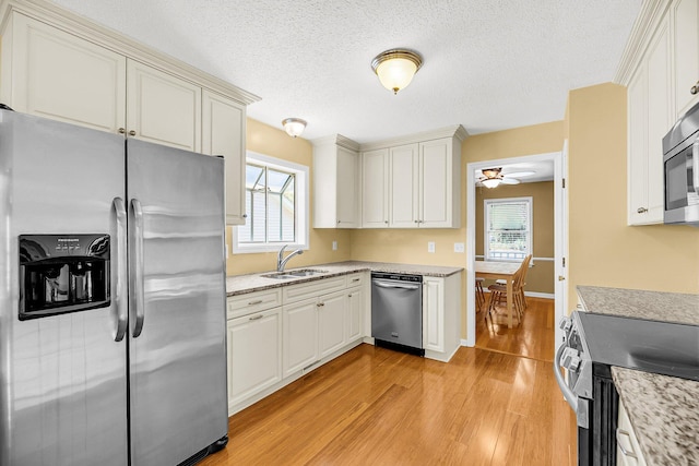 721 Lake Frances Dr, Charleston, SC 29412 - kitchen with stainless steel appliances, light wood finished floors, a ceiling fan, a textured ceiling, and light stone counters