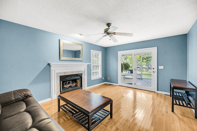 721 Lake Frances Dr, Charleston, SC 29412 - living area with light wood-type flooring, a tile fireplace, ceiling fan, and a textured ceiling