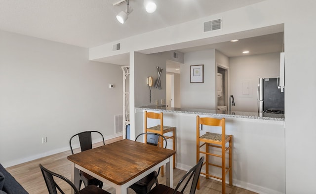 dining room with sink and light hardwood / wood-style floors