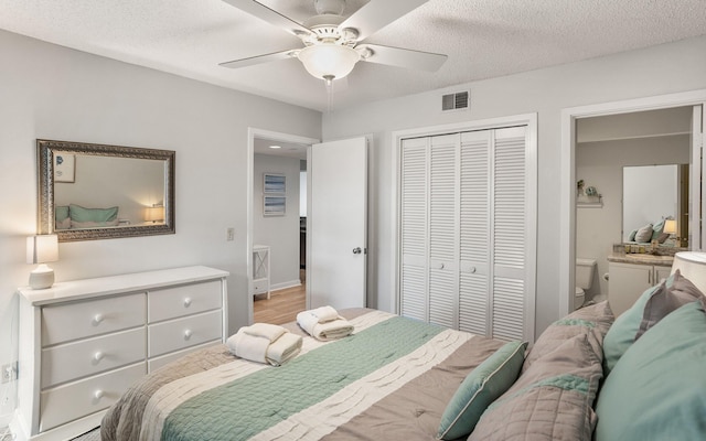 bedroom with a textured ceiling, light wood-type flooring, a closet, and ceiling fan