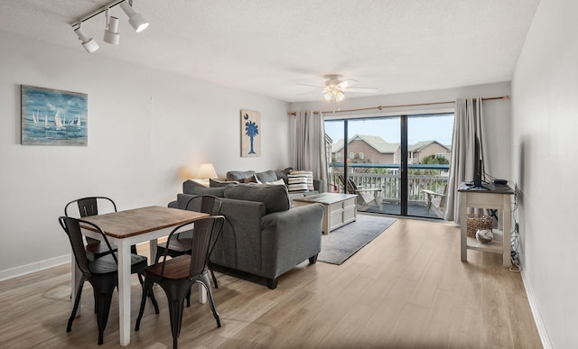 living room featuring light hardwood / wood-style flooring, a textured ceiling, rail lighting, and ceiling fan