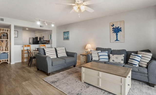 living room with track lighting, light hardwood / wood-style floors, and ceiling fan