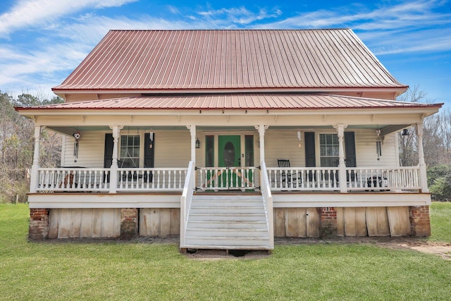 country-style home with a front lawn, covered porch, and metal roof