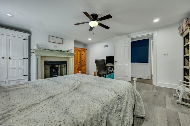 bedroom with a fireplace, recessed lighting, wood finished floors, and baseboards